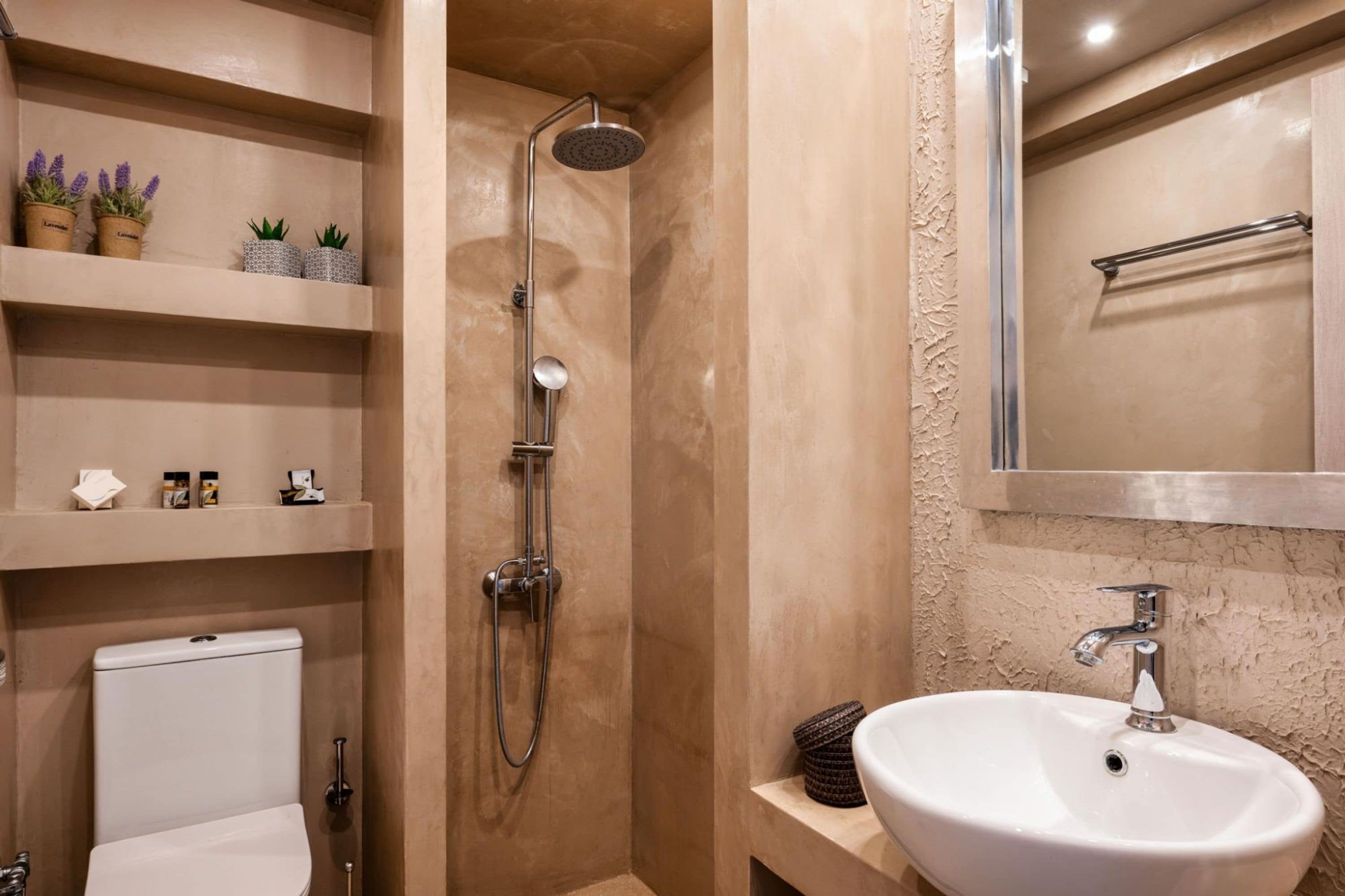 A bathroom with a shower, toilet, sink, and shelves with toiletries.