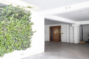 A hallway with a green wall, a wooden door, and a number '15 17' on the wall.