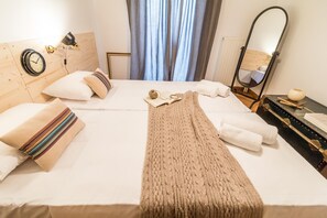 Relax in comfort with a neatly made bed, white towels, and a cozy throw.