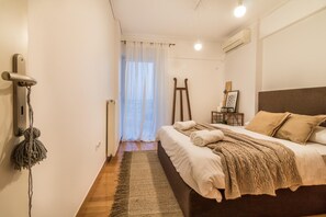 Relax in a serene space with a large bed, wooden nightstand, and sheer curtains.