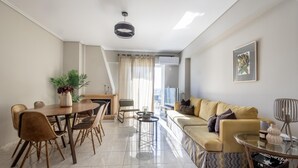 En moderne stue med spiseområde, sofa, sofabord og pejs.