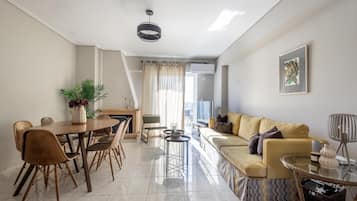 A modern living room with a dining area, a sofa, a coffee table, and a fireplace.
