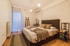 Cozy retreat with a large bed, nightstand, and air conditioning for a comfortable stay.