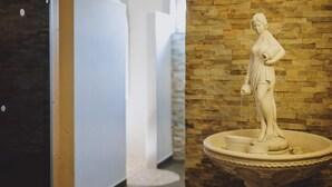 A marble statue on a pedestal in a hallway with a brick wall. - Appartements Sulzer - TOP 13 (Zell am See)