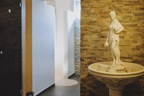 A marble statue on a pedestal in a hallway with a brick wall. - Appartements Sulzer - TOP 13 (Zell am See)