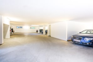 A parking garage with a blue car parked on the right.