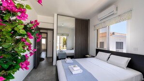 Een moderne hotelkamer met een groot bed, nachtkastje, spiegel en raam met uitzicht.