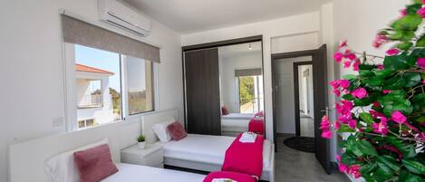 A hotel room with two beds, a large mirror, and a view of the outside.