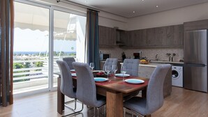 Una cocina moderna con comedor, ventanas amplias y vista al mar.