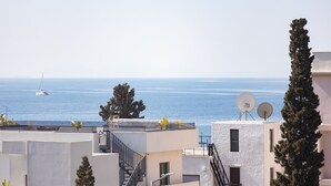 Un edificio costero con antenas parabólicas, una escalera y vista al mar.