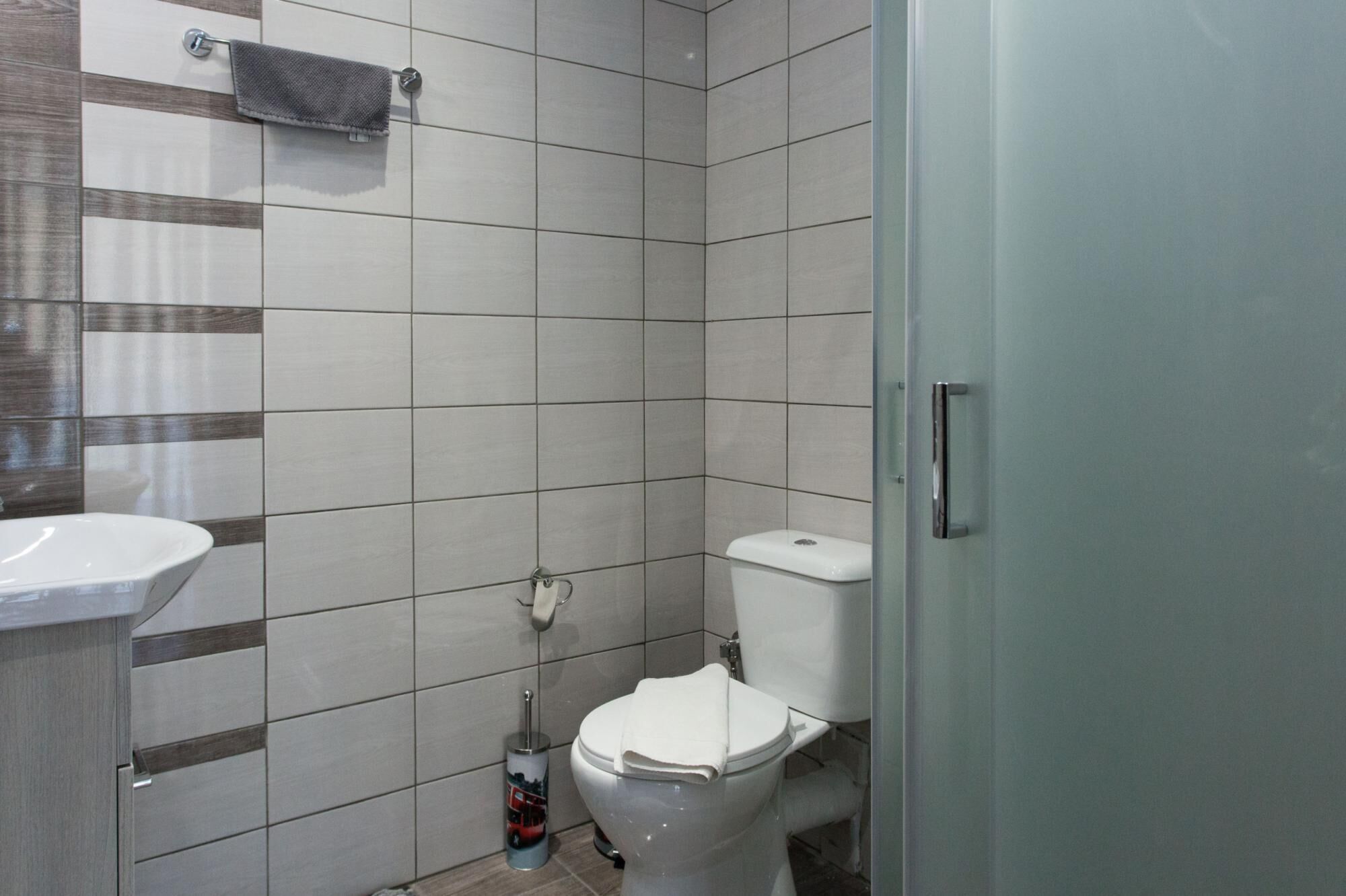 A bathroom with a toilet, a sink, and a towel rack.