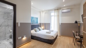 Un dormitorio moderno con una cama grande, un escritorio y una zona de ducha.
