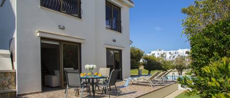 Une maison à deux étages dotée d’un patio, d’un espace salon extérieur et d’une piscine.