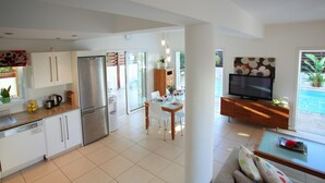 Une cuisine moderne équipée d’un réfrigérateur, d’une cuisinière et d’un coin repas avec une table mise pour deux personnes.