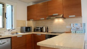 Eine moderne Küche mit Holzsärchen, einer Mikrowelle, einem Toaster und einem Wasserkocher.