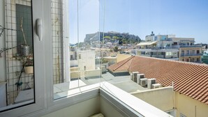 A balcony with a view of a cityscape, including a prominent hill with buildings. - 3 Bdrm Luxury Apt Incredible Acropolis View (Athens)