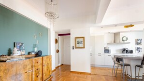 A modern kitchen with a wooden countertop, white cabinets, and a herringbone floor pattern. - 3 Bdrm Luxury Apt Incredible Acropolis View (Athens)