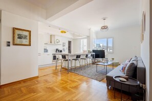 A modern living space with a kitchen, dining area, and seating area.