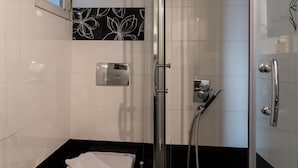 Uma casa de banho moderna com sanita, bidé e chuveiro.