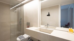 A modern bathroom with a glass shower enclosure, a white sink, and a large mirror. - Elegant Retreat in Kolonaki - Renovated April 2026 (Athens)