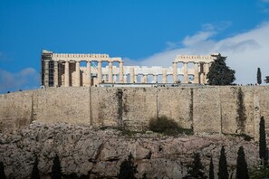A historical building with columns and a stone wall. - Modern - Vintage Apartment by Acropolis Museum (Athens)