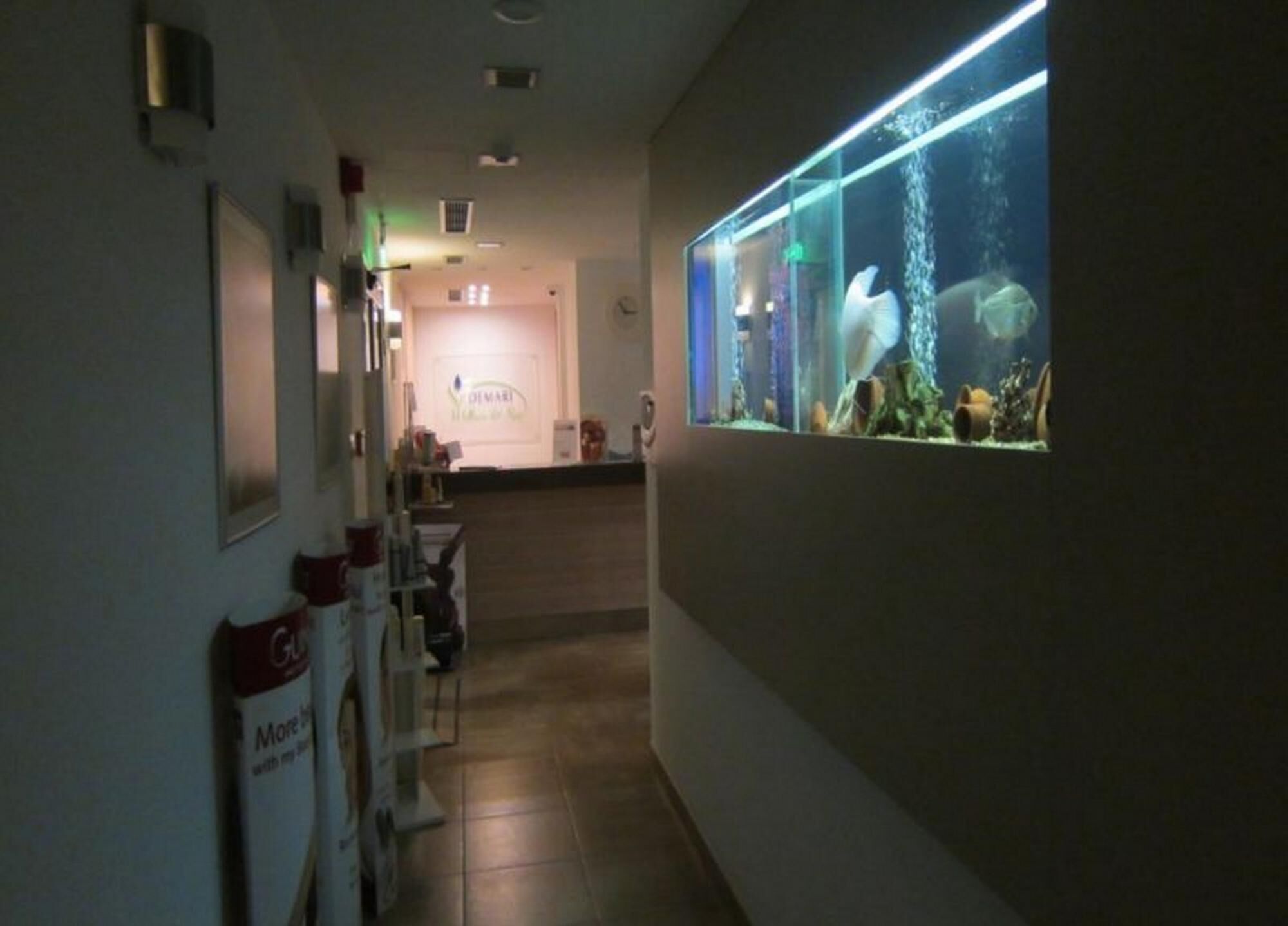 Ein Flur mit einer Rezeption, einem Aquarium und einem Schild mit der Aufschrift 'More with my brand'.