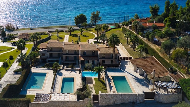 A coastal hotel with multiple swimming pools, a central courtyard, and a view of the sea. - Palmrise Luxury Villas - Blue Villa (Kassandra)