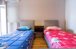A bedroom with two beds, each with a headboard and a pillow.
