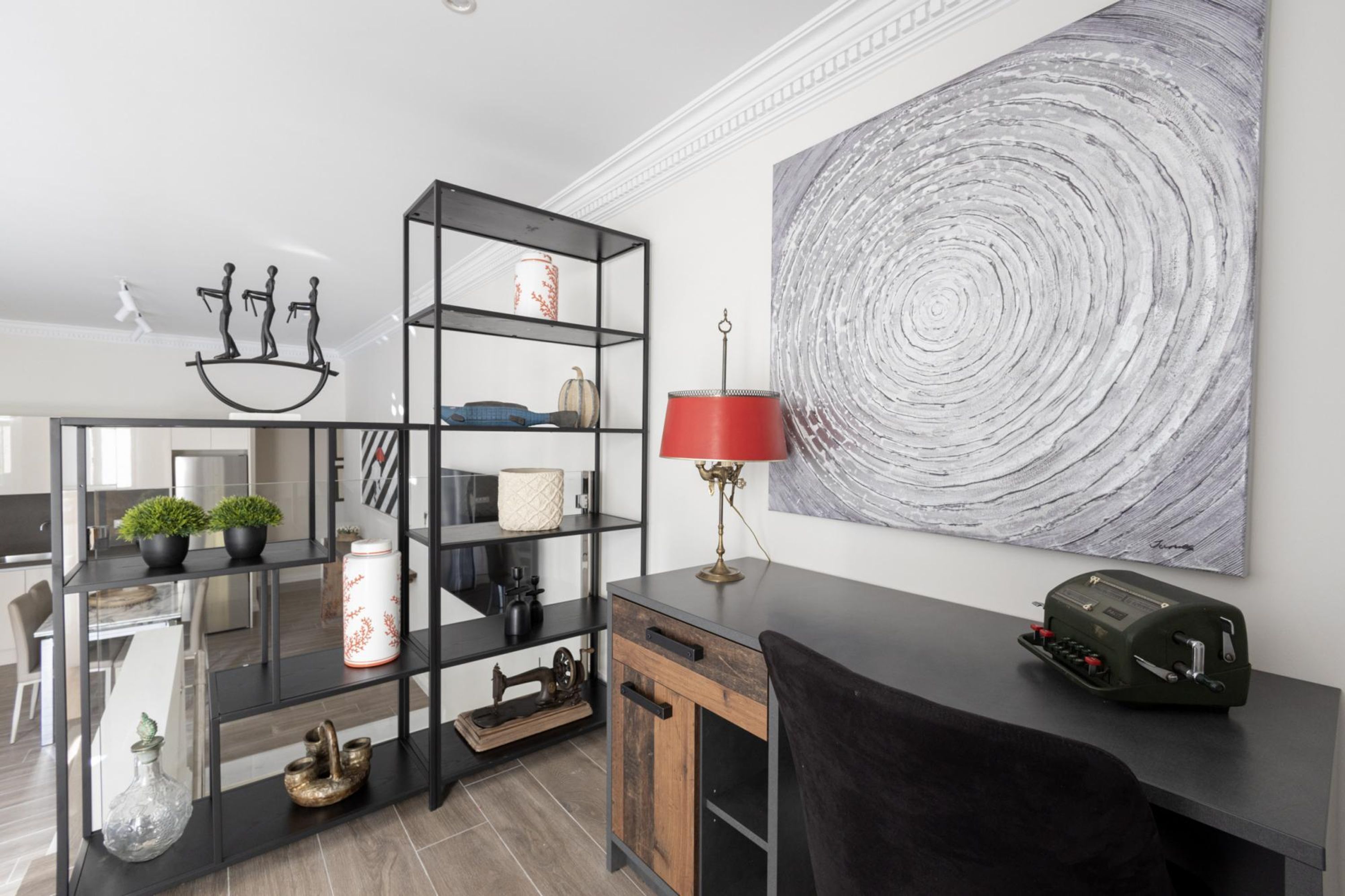 A modern living room with a black shelving unit, a red lamp, and a vintage radio.