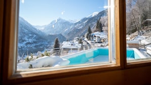 Blick auf eine Berglandschaft mit einem Pool im Vordergrund.