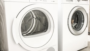 Deux machines à laver à chargement frontal, de couleur blanche, dotées de panneaux de commande et d’une petite grille pour les haut-parleurs.