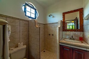 A bathroom with a shower, toilet, sink, and a large mirror. - Casa 48· Poolside Relaxing Retreat Near the Beach (Esterillos Este)