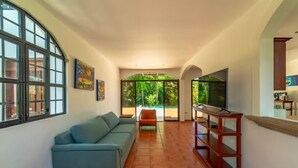A living room with a sofa, TV, and a wooden cabinet. - Casa 48· Poolside Relaxing Retreat Near the Beach (Esterillos Este)