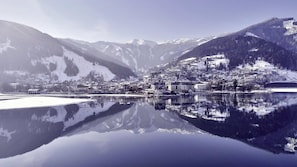 A serene lakeside town with snow-covered mountains in the background. - Appartements Sulzer - TOP 12 (Zell am See)