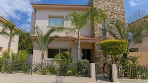 A two-story house with a stone facade and a flat roof.