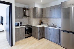 Enjoy cooking in this well-equipped kitchen with a stainless steel refrigerator, oven, and microwave.