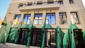A modern building with a flat roof, multiple windows, and a gated entrance. - 85 sqm in the Heart of Athens w Rooftop Deck (Athens)
