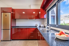 Enjoy a meal with a view from the kitchen, which features a large window and a stainless steel refrigerator.