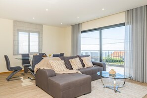 Relax in this stylish living room with a sofa, coffee table, and dining area.