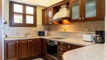 A kitchen with wooden cabinets, a microwave, a toaster, and a coffee maker.