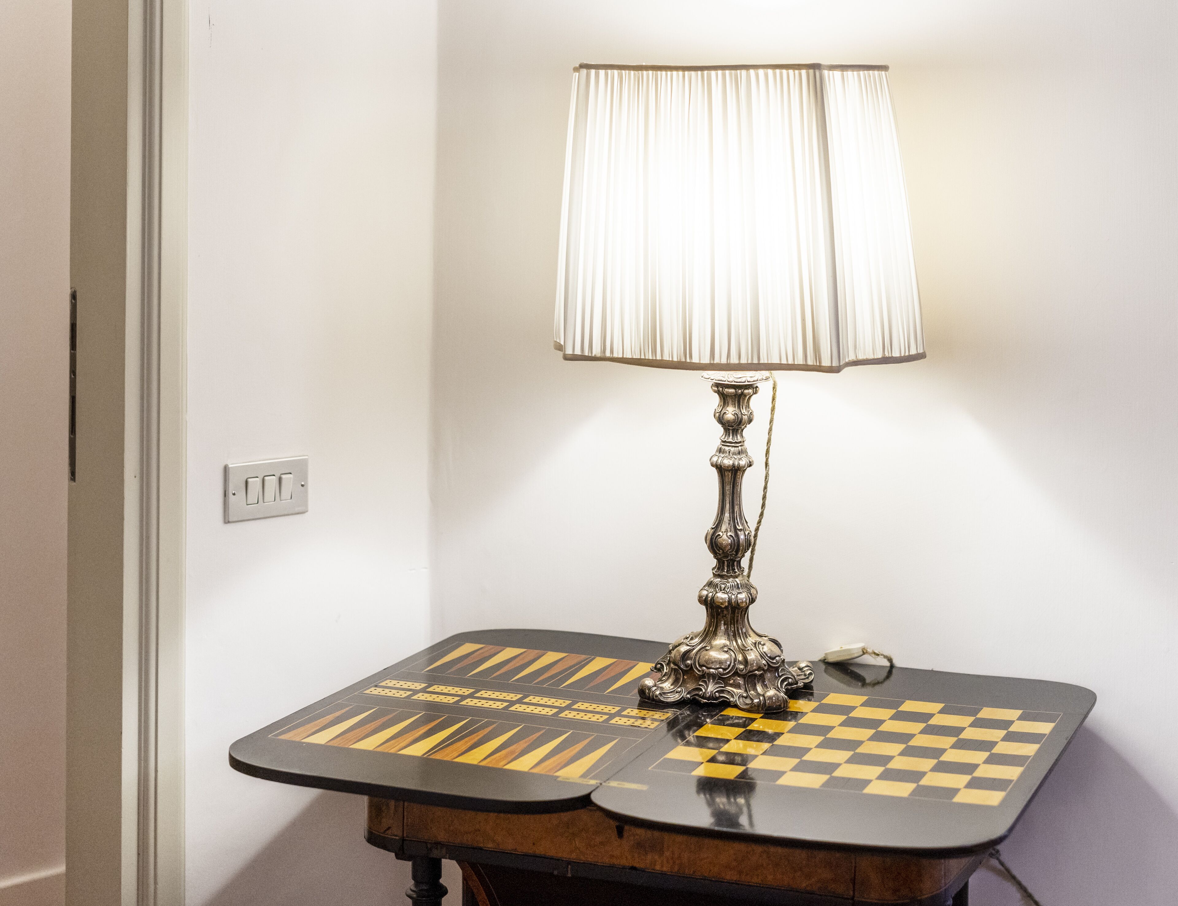 A table with a chessboard and a lamp.