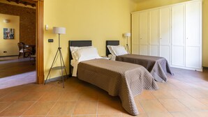 A room with two beds, a lamp, a wardrobe, and a chair. - Verdi 11 - Two Bedroom Apartment, Sleeps 4 (Firenze)