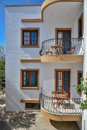 Stunning two-story residence with a modern design, featuring balconies with wrought iron railings and wooden accents.
