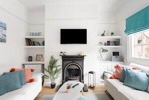 Cozy living space with a fireplace, flat-screen TV, and comfortable sofas.