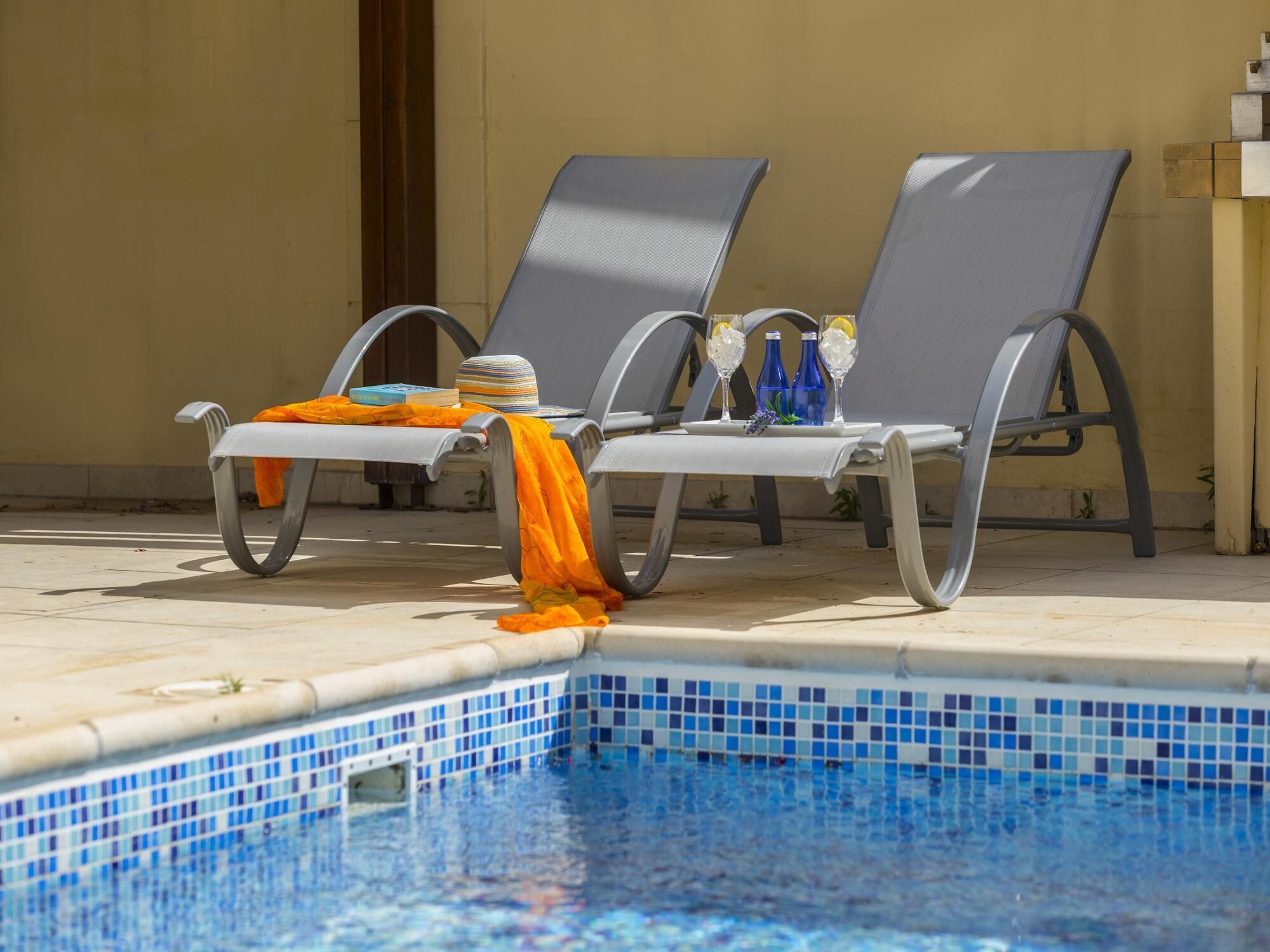A poolside area with lounge chairs and a tiled pool.