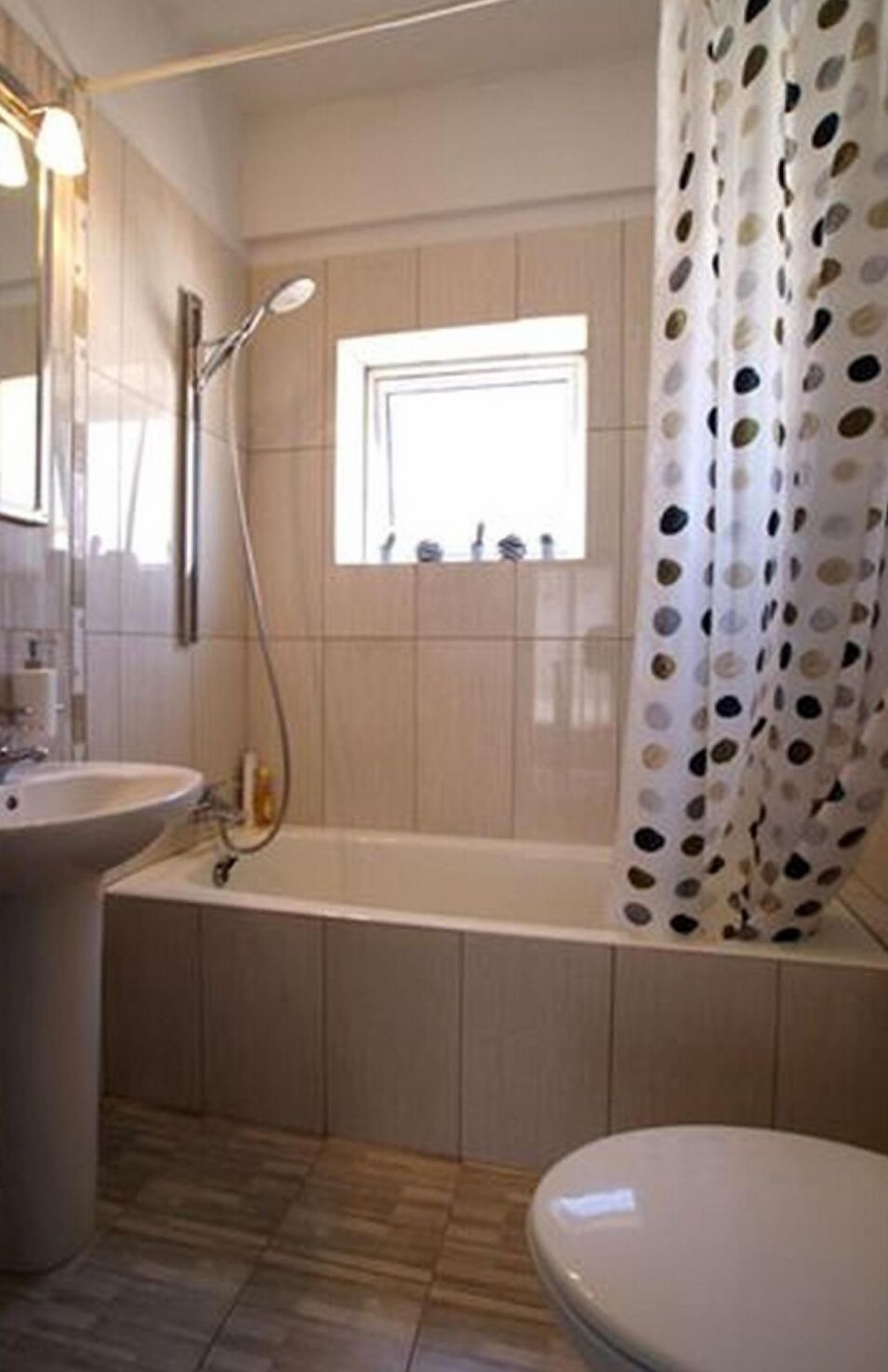 Een badkamer met een bad, een wastafel en een toilet.