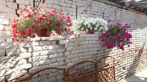 Una pared de ladrillo blanco con cestas de flores colgantes.