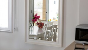 Una cocina con armarios blancos, encimera blanca y una ventana con vistas al exterior.