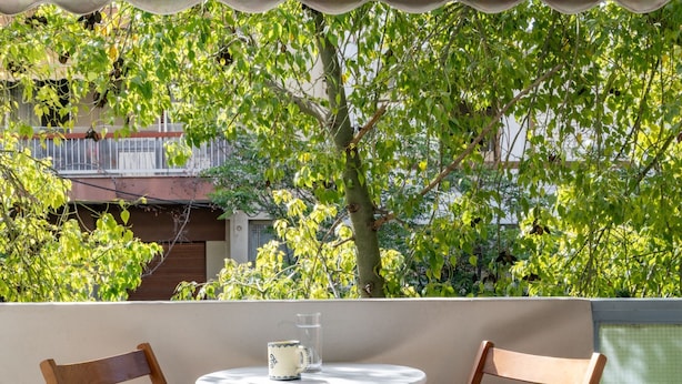 Une table ronde avec deux chaises en bois, un verre et une tasse.