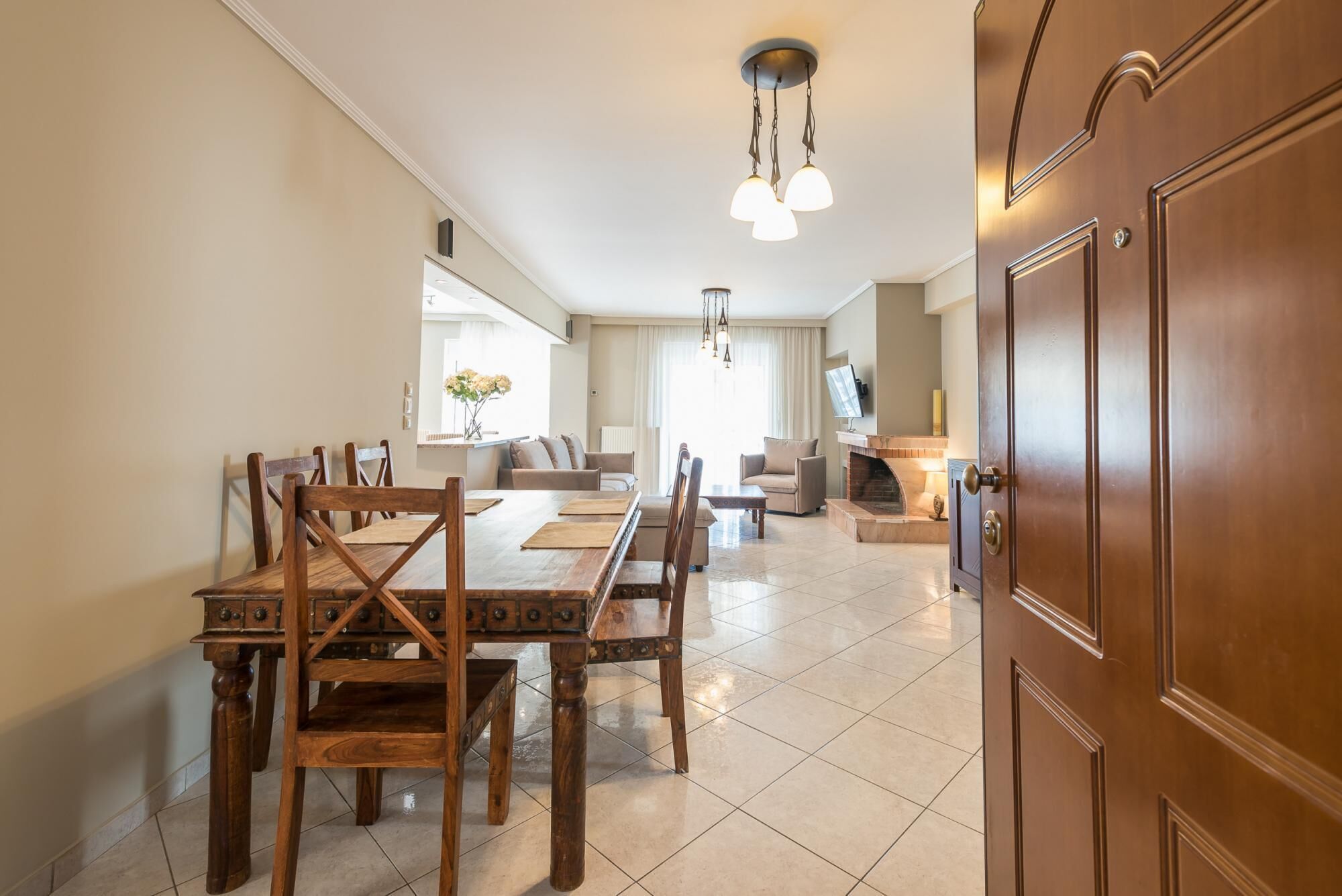 Uma sala de estar ampla com uma mesa de jantar, sofás e uma lareira.
